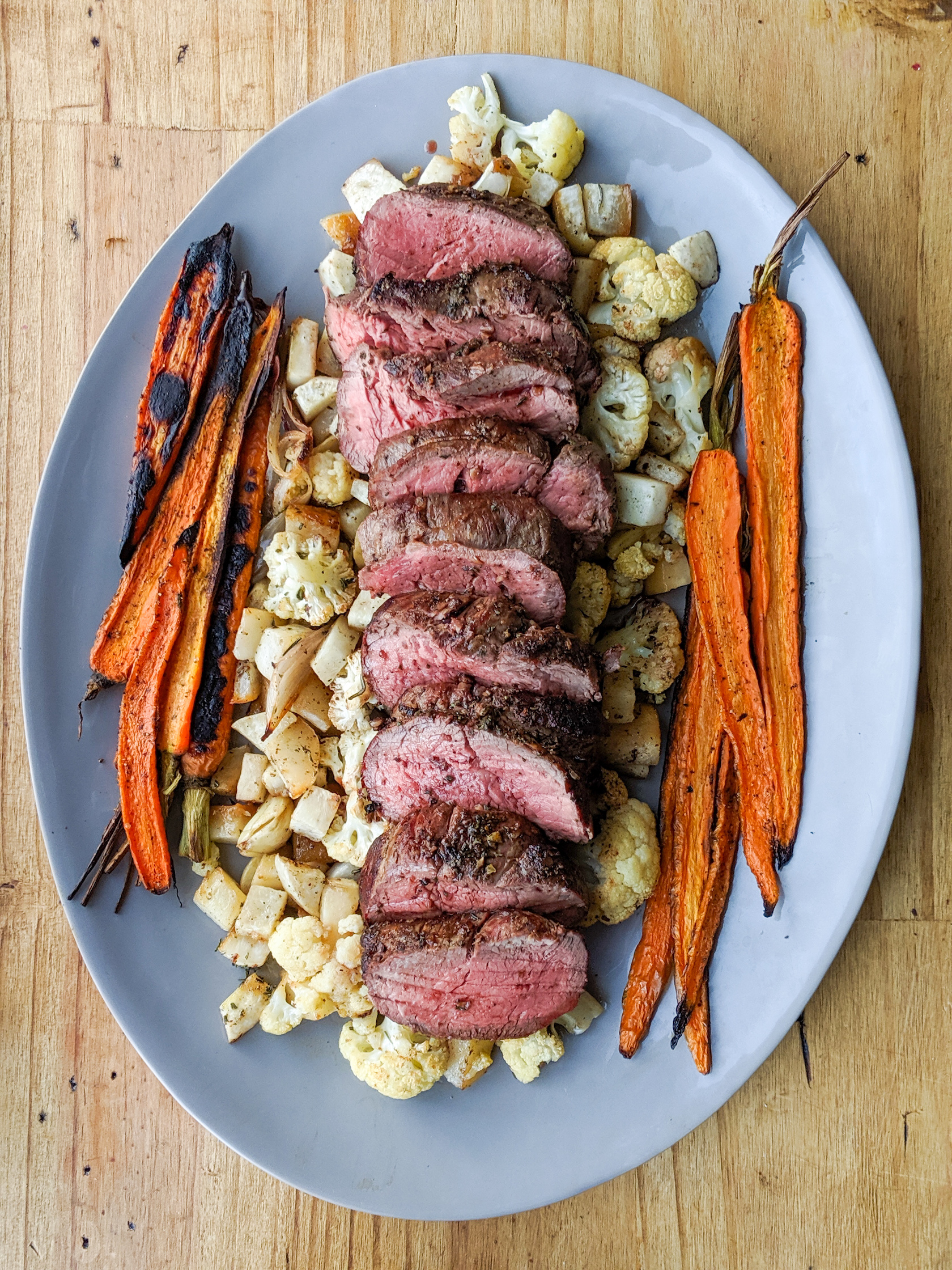 Platter of roast beef tenderloin with carrots, turnips and cauliflower