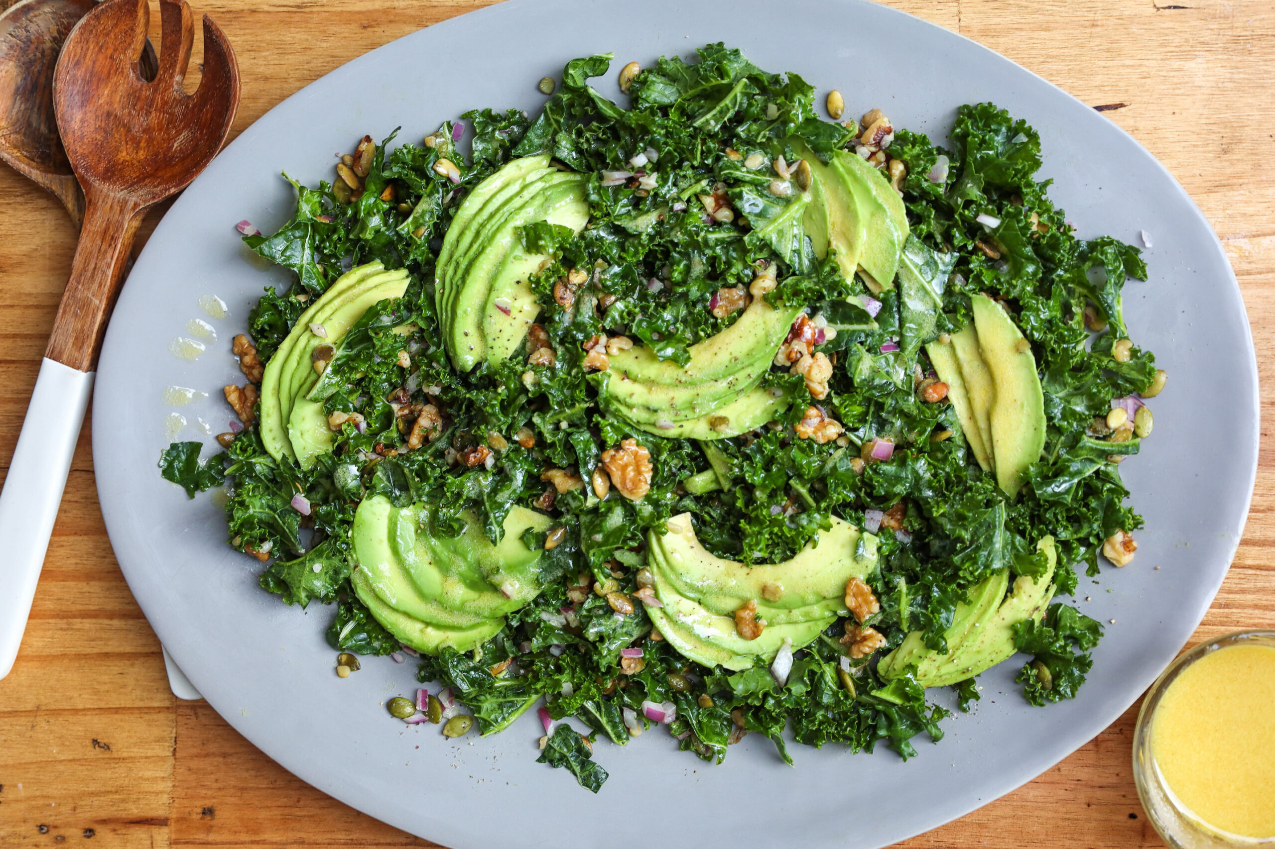 kale salad with walnuts, pumpkin seeds avocado and dijon vinaigrette